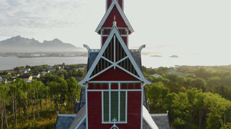 The top of an old village church on a background of green forest, mountains and the sea in the distanceの写真素材