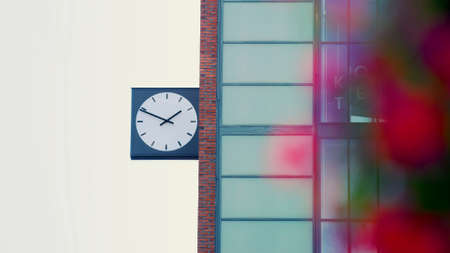 Close-up large dial clock attached to the side of a brick building in Helsinki