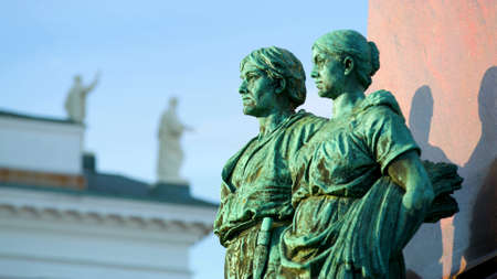 Two metal statues of a man and a woman painted green, close-up, in Helsinkiのeditorial素材