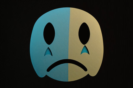 Sad emoticon on a dark backgroundの素材