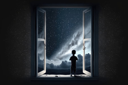 Little boy looking out of open window at night skyの素材