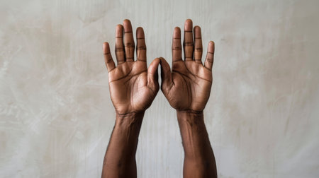 Two human hands with the palms facing forward, set against a light textured backgroundの素材