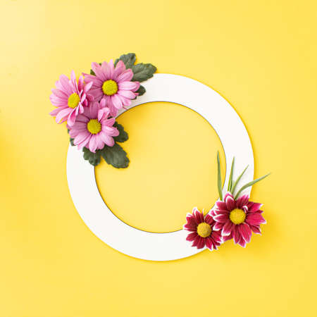 Vibrant color spring blooming flowers  arranged in cyrcle shape with copy space on illuminating, yellow color  background. Minimal creative concept.の写真素材