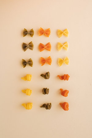 Italian pasta various of shapes and colors, arranged in a square on pastel background. Minimal flat lay concept.の写真素材