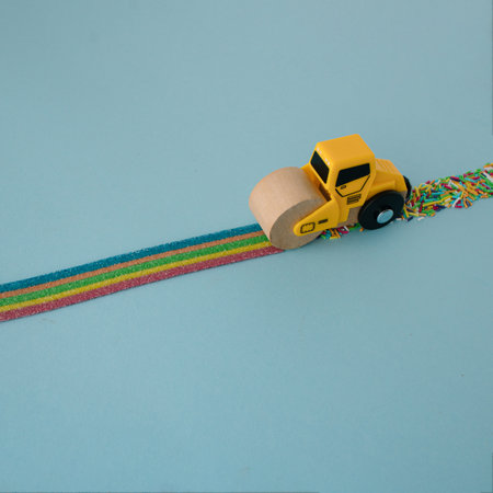 A playful rainbow concept with a variety of sweets set as the line along which the toy roller goes. rainbow street. pastel blue background. minimal creative concept.の写真素材