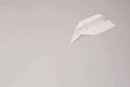 Flying paper airplane on bright background. minimal creative concept.の写真素材