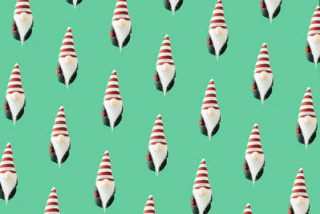 Christmas and New Year 2022 pattern concept. A Christmas dwarf with a red and white hood and white...