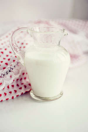 Glass jar of milk on a white surfaceの写真素材
