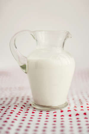 Glass jar of milk on a white surfaceの写真素材