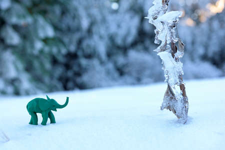 Plasticine green elephant adventure with frozen plant on snowの写真素材