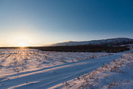 Sunset winter landscape with snow-covered fieldの写真素材