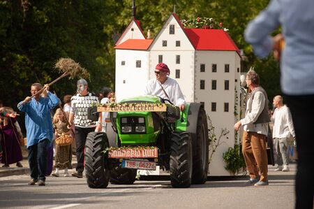 Germany, Baden Wurttemberg, Niederstetten. September 2019. Traditional autumnal Harvest Fest. Decorated tractor with castlのeditorial素材