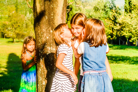 Little girls are playing and whispering in the park.の写真素材