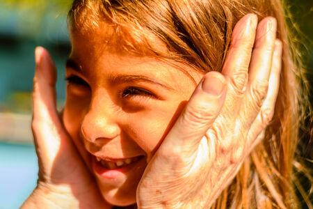 Grandmother holding her Granddaughter in her hands.の写真素材