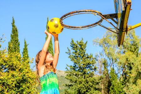 Seven year old girl is playing basketball