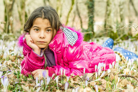 Beautiful girl laying in the flowers in the forestの写真素材
