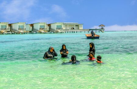 Muslim women swimming in tradicional burka on the beach in Maldiveの写真素材