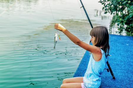 Little girl fishing on the river Bojana in Montenegroの写真素材