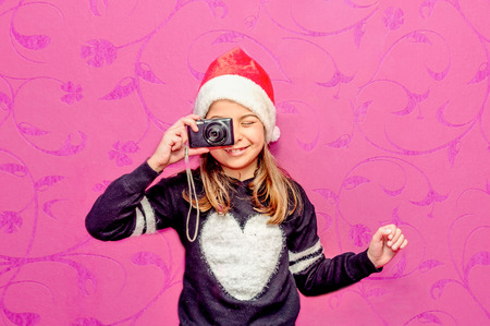 Happy child girl in a Christmas taking a picture with cameraの写真素材