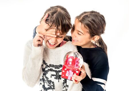 Little girl giving surprise love gift to her friend with white backgroundの写真素材