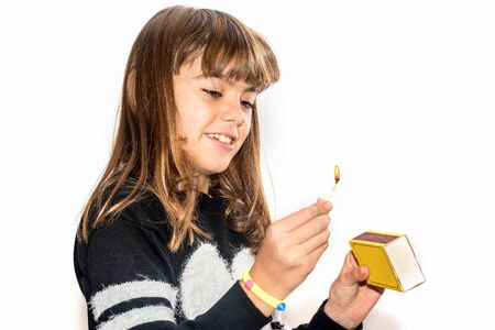 Eight year old girl playing with maches isolated on white