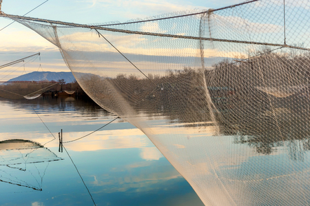 Fishing net on the river Bojana, Montenegro with clouds reflectionの写真素材