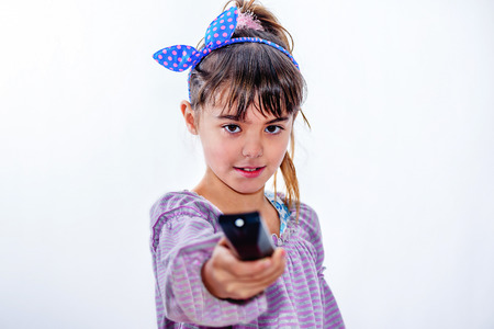 Little girl holding remote control isolated on white