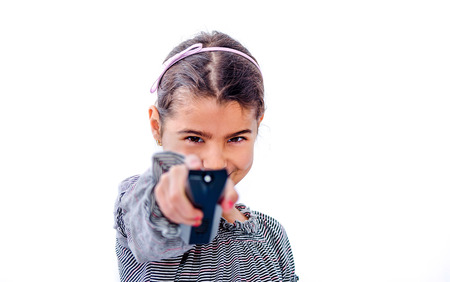 Little girl holding remote control isolated on whiteの写真素材