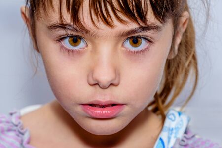 Portrait close up of a beautiful little girl with amazing brown  eyes