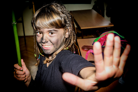 Portrait of a happy little girl with face painted with charcoal for maskenballの写真素材