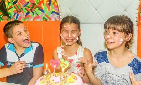 Twin sisters at  birthday celebration with cake
