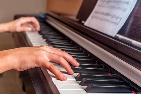 Hands of a little girl playing the piano