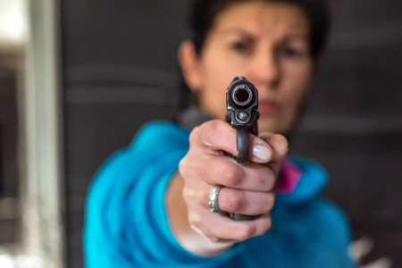 Woman aiming gun at the camera