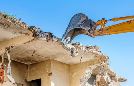 Demolition of an old house with excavatorの写真素材