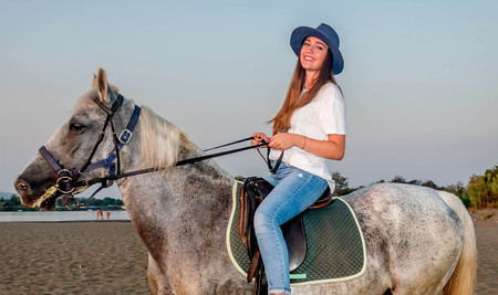 Girl with a hat riding a horseの写真素材
