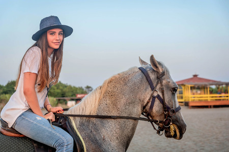 Girl with a hat riding a horseの写真素材