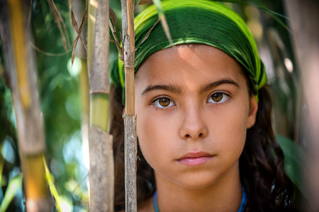 Portrait of a little girl in the bushesの写真素材
