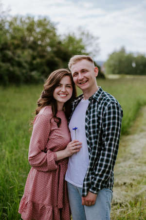 Happy young couple, a guy and a girl, look into the camera and smileの写真素材