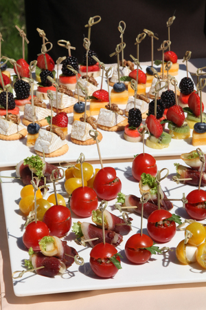 Beautifully decorated catering banquet table with different food snacks and appetizers with sandwich, fresh fruits on corporate christmas birthday party event or wedding celebrationの写真素材