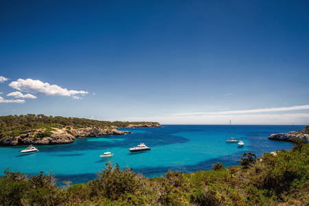 Beautiful view of the bay with turquoise water and yachts in Cala Mondrago National Park on Mallorca...