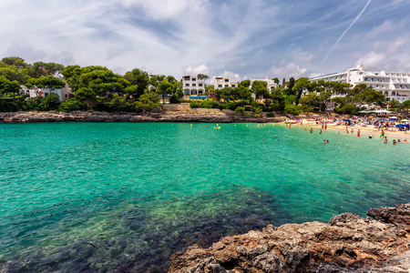 Cala Gran beach with turquoise water crowded with tourists in Mallorca, Spainの写真素材