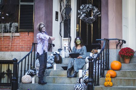 BOSTON, USA - OCTOBER, 2015: Adult couple dressed like zombie and a witch posing near their house on Halloween,のeditorial素材