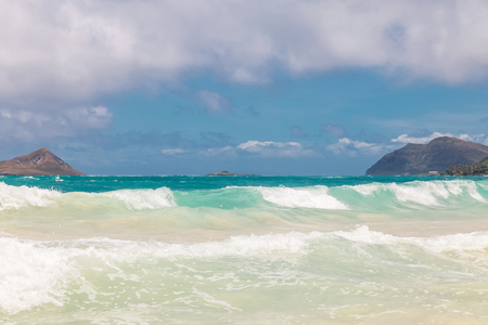 Beautiful Waimanalo beach with turquoise water and cloudy sky, Oahu coastline, Hawaiiの写真素材