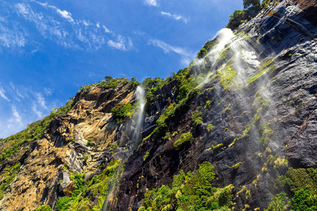 High waterfalls in Milford Sound, New Zealand, picture taken from cruise ferryの写真素材