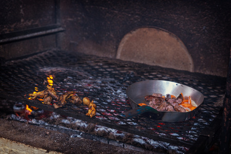 Cooking traditional chicken feet and meet sausage on a coal grill in South African reastaurantの写真素材