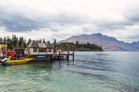 QUEENSTOWN, NEW ZEALAND - DECEMBER, 2017: Wakatipu lake and pier with tour boats in Queenstownのeditorial素材