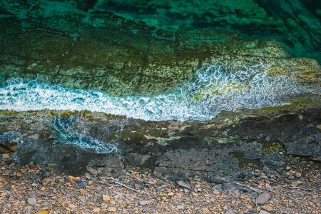 Aerial view of rocky coastline and turquoise sea water