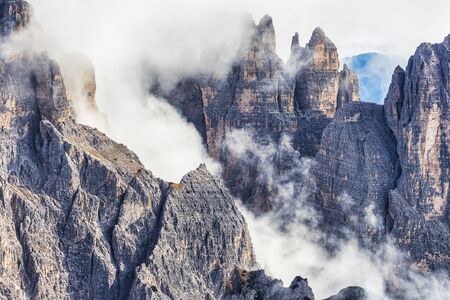 Huge rocky mountains view covered with clouds, Dolomites, Italyの写真素材