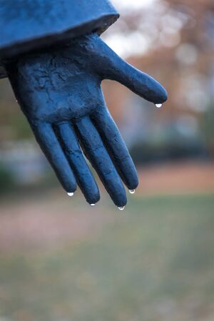 Hand of the statue with water drops on the fingers after the rainの写真素材