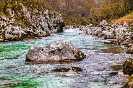 Rocky banks of emerald Soca river in autumn season in Slovenia